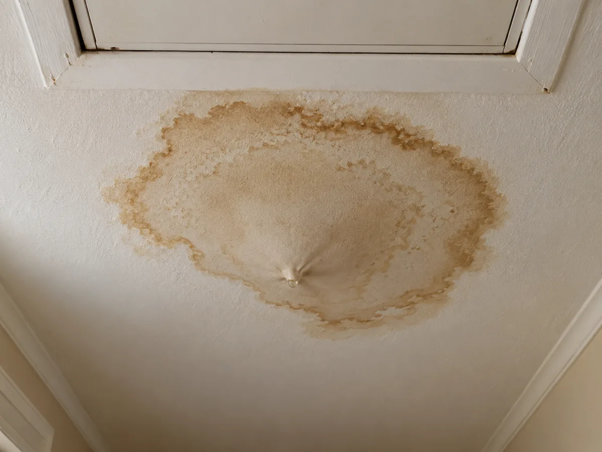 Brown water ring on a hallway ceiling below an attic water heater, Dallas, TX
